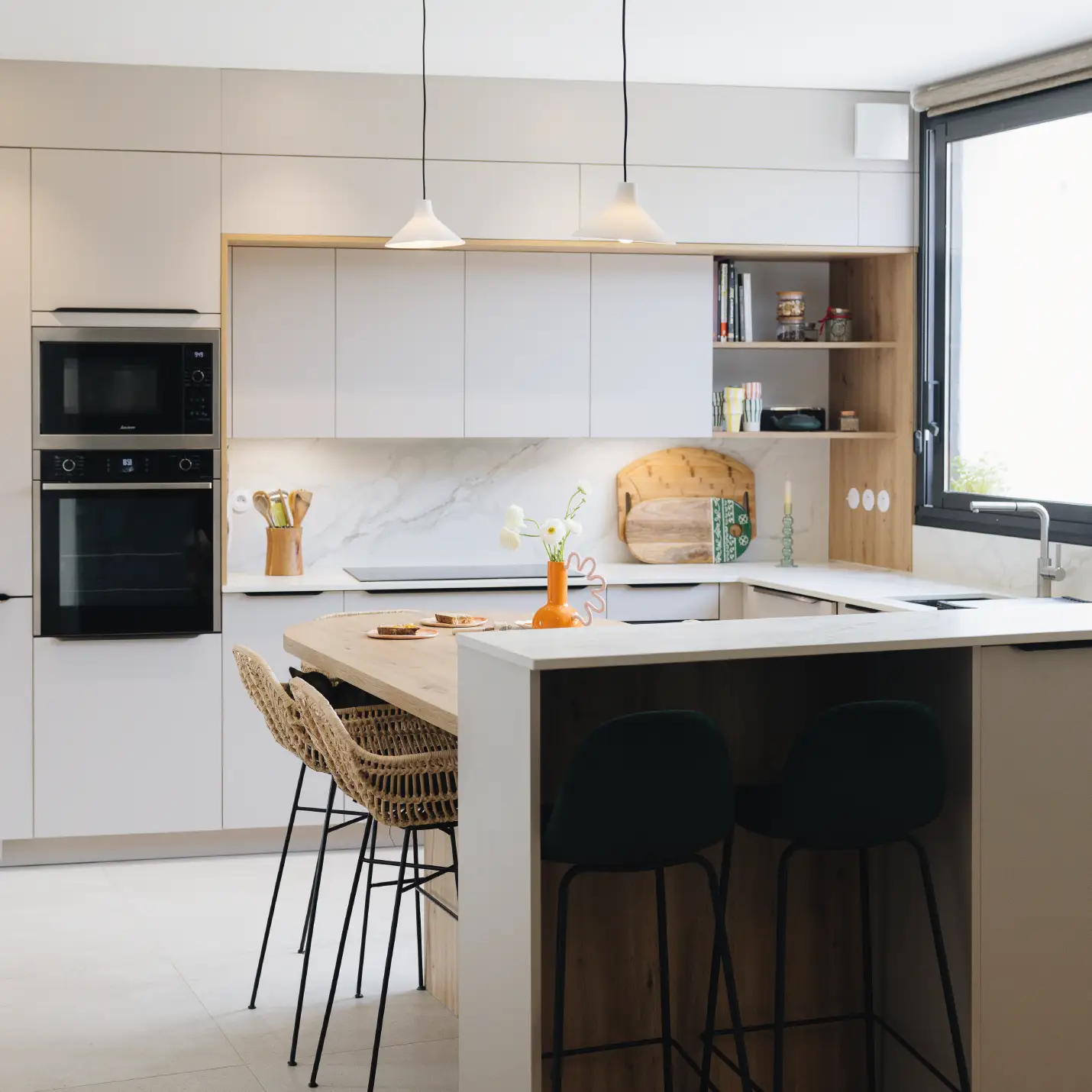 Photographie d'une cuisine en U avec un plan snack, de coloris gris clair et avec un plan de travail en bois